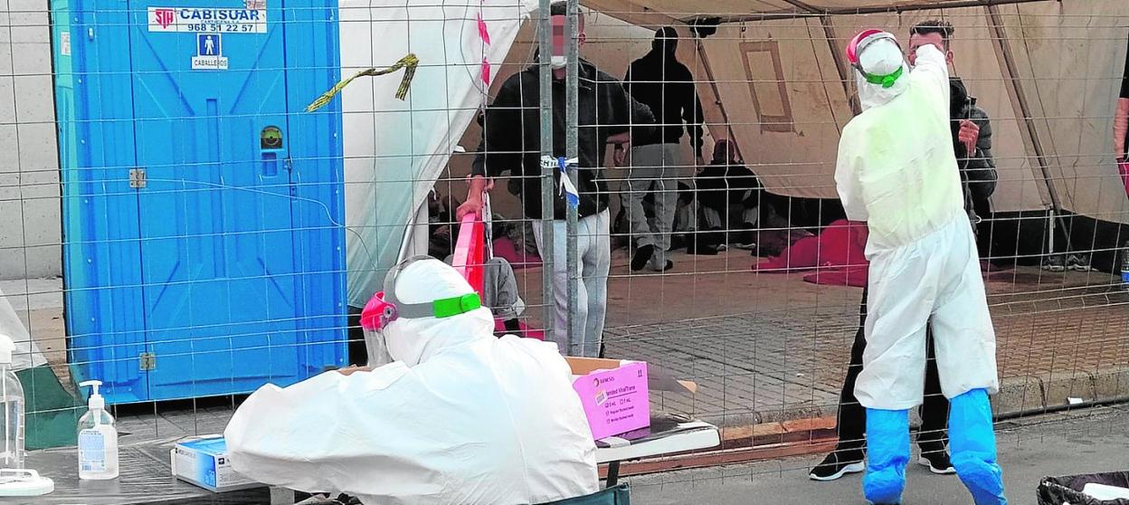 Sanitarios en Escombreras realizan, ayer, pruebas PCR a los inmigrantes argelinos llegados en patera en las últimas horas. 