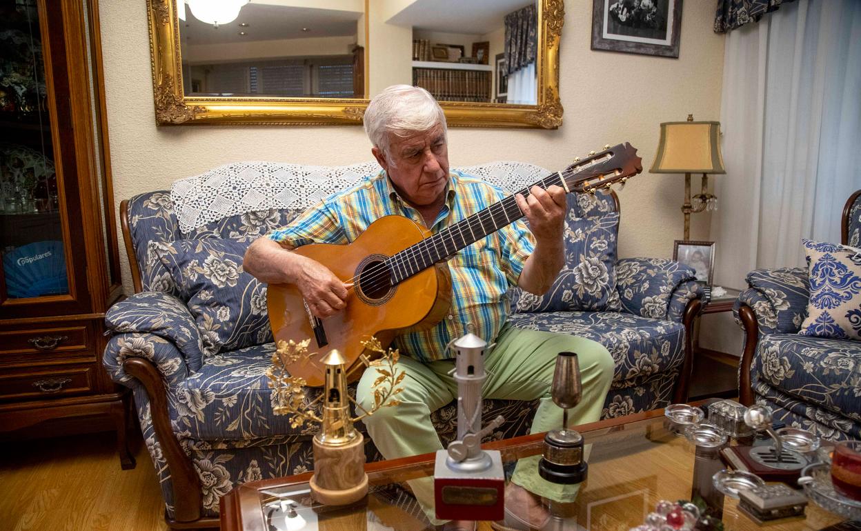 Antonio Piñana, con su guitarra y algunos de los trofeos más importantes conseguidos por su padre. 