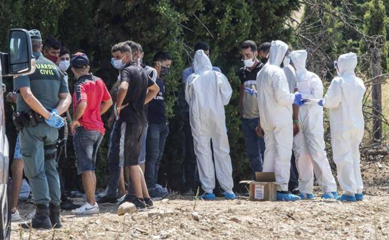 Sanitarios de Cruz Roja y agentes de la Guardia Civil atienen a inmigrantes llegados a Cartagena, en una imagen de archivo.