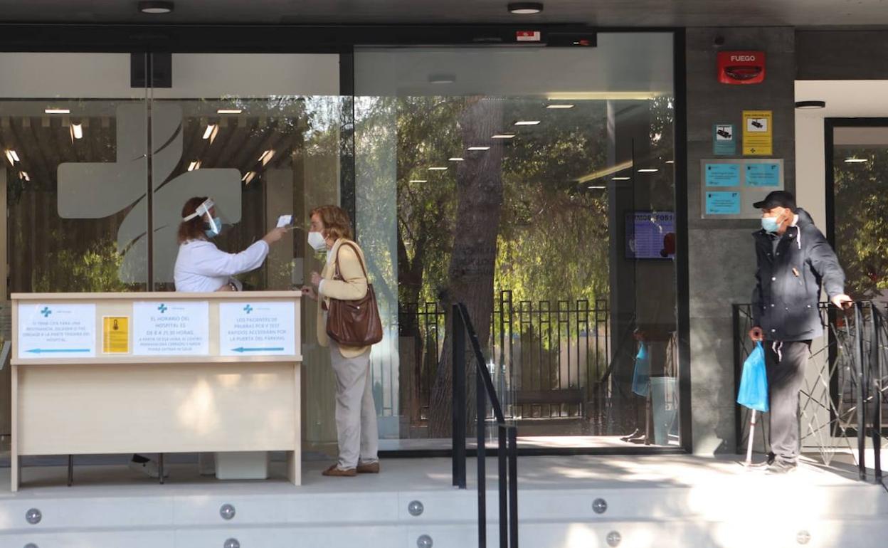 Toma de temperatura a una mujer en la entrada del hospital Virgen del Alcázar de Lorca.