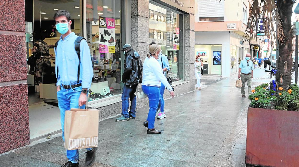 Viandantes a las puertas de un comercio de la avenida Juan Carlos I. 