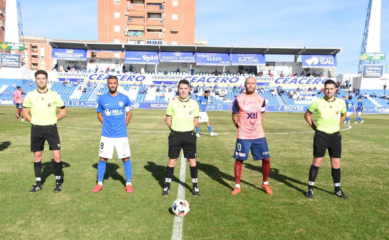 Los capitanes y el trío arbitral posan tras saltar al césped.