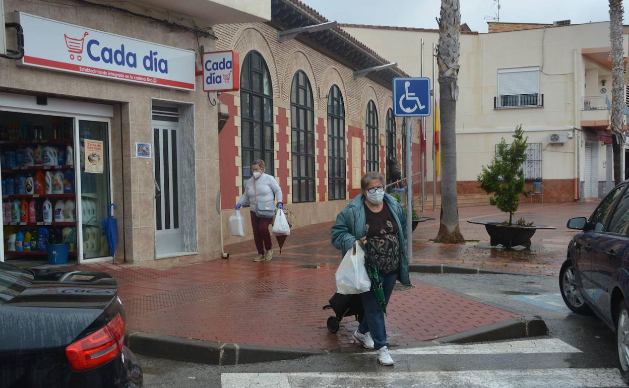 Dos vecinas de Campos del Río caminan por una calle con sus bolsas después de hacer la compra, durante la primera oleada. 