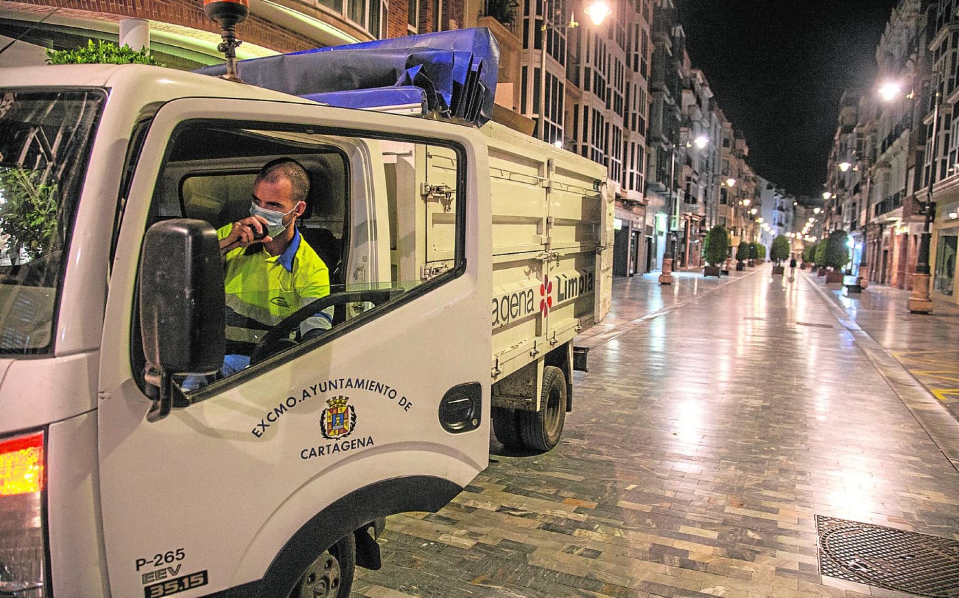 José Manuel Avilés sube al camión de recogida de cartón en comercios por la calle del Carmen, antes de medianoche. 