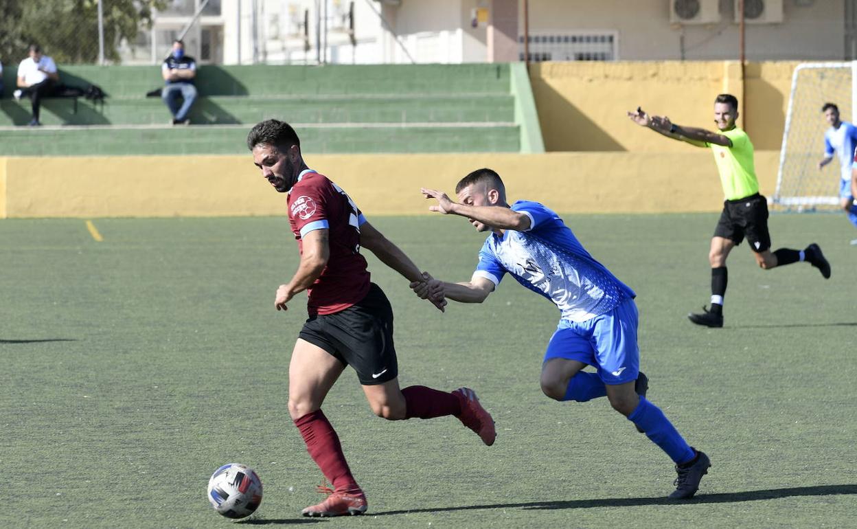 Un jugador del Plus Ultra persigue a uno del Águilas en el encuentro de esta temporada en Tercera División.