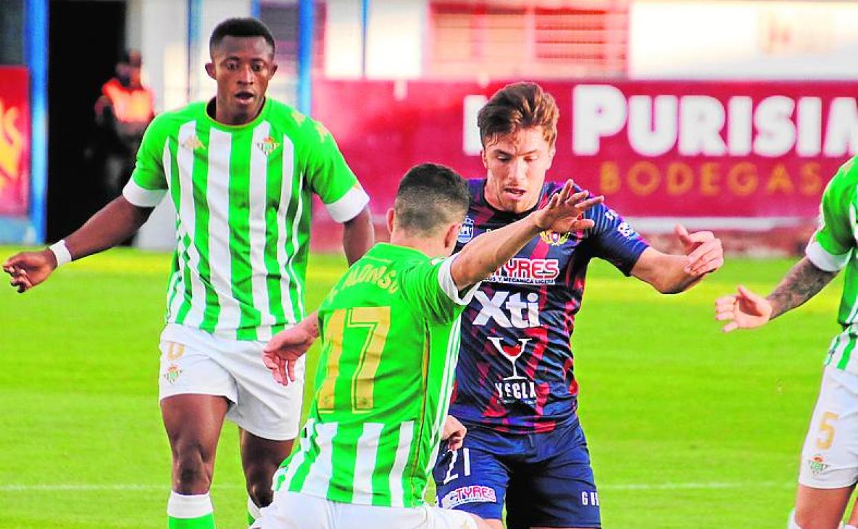 Luis Castillo controla el balón, ante el acoso del bético Julio Alonso, en el partido disputado este domingo.