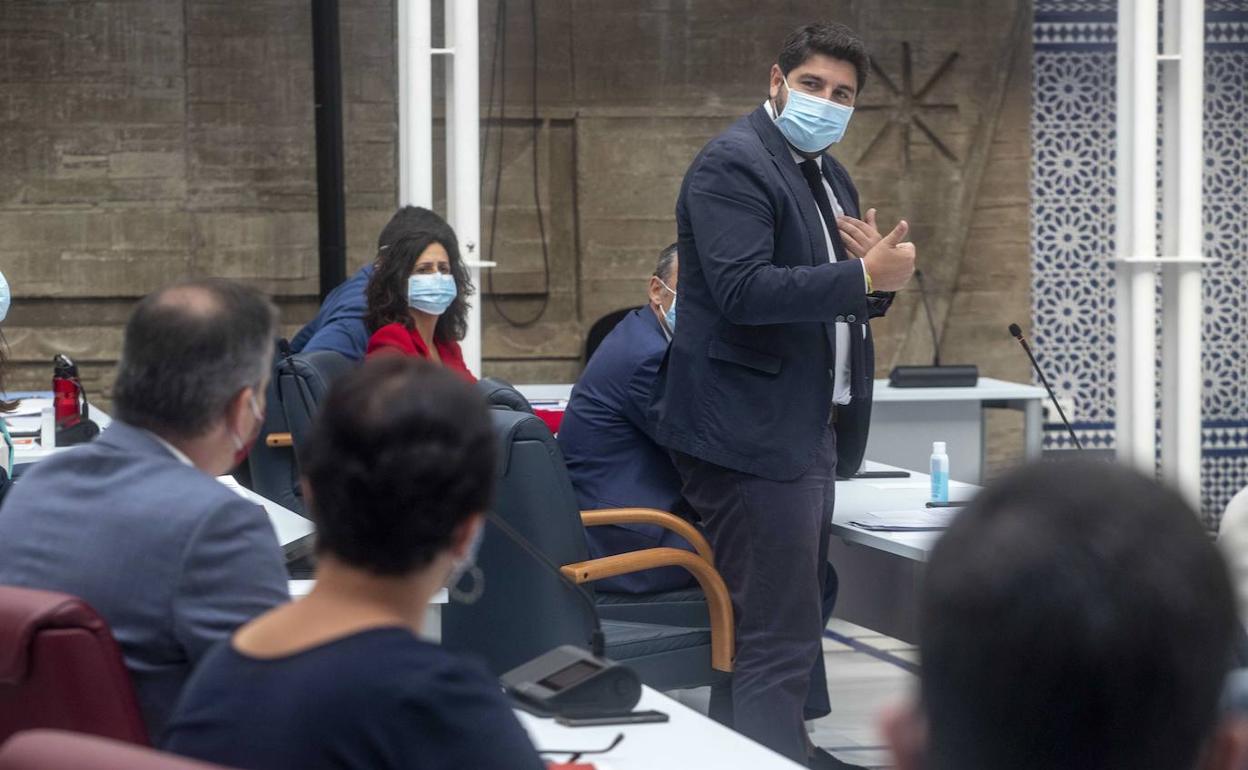 López Miras se dirige a Diego Conesa, de espaldas, durante un pleno en la Asamblea Regional. 