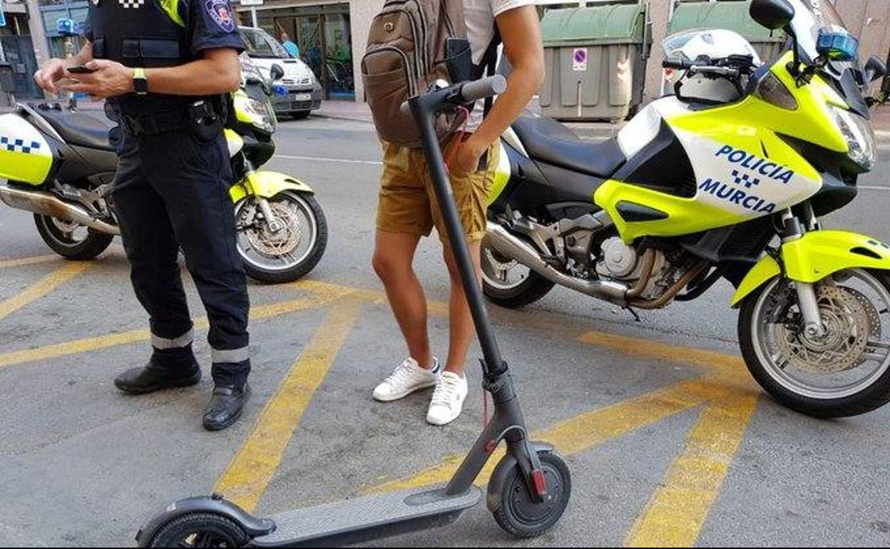 Una persona que utilizaba un patinete eléctrico, detenido por circular por la calzada, en una foto de archivo.
