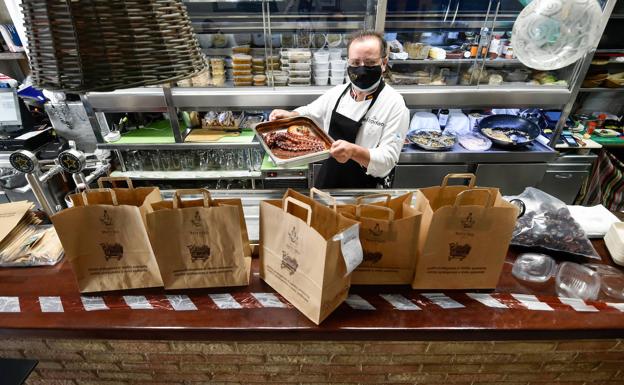 Pepe El Torrao prepara, tras la barra de su bar, varios envíos para su reparto.