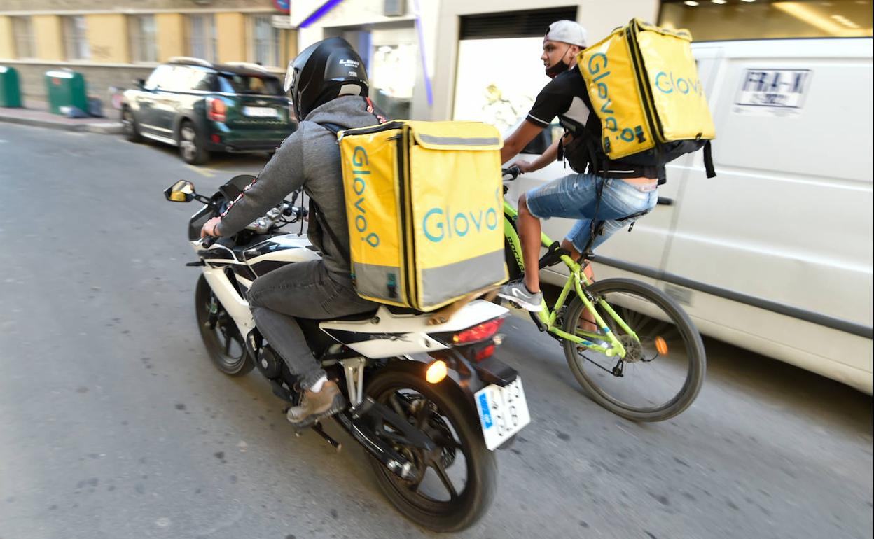 Dos 'riders' de Glovo acuden a realizar una entrega, ayer, en Murcia.