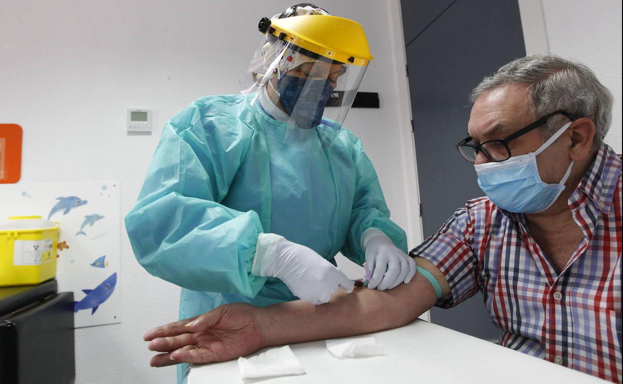 Un sanitario realiza un test de anticuerpos a un paciente, en una fotografía de archivo.