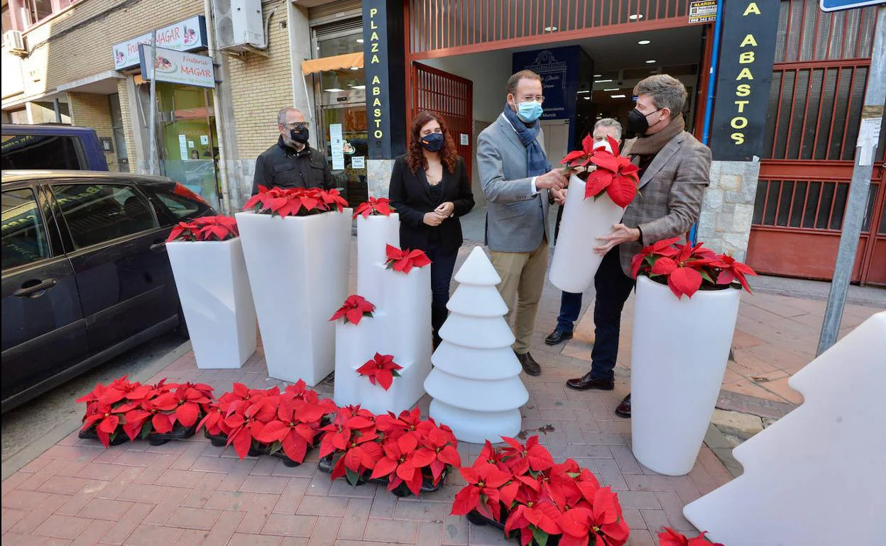 Reparto de flores de pascua y adornos navideños a los comerciantes del barrio del Carmen. 