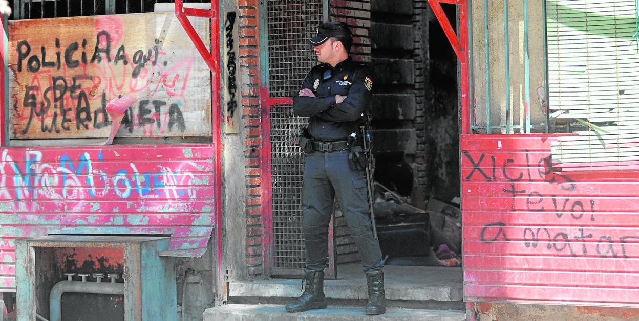 Un policía vigila en la puerta del bloque donde se efectuó la redada de La Paz, en el año 2015. 