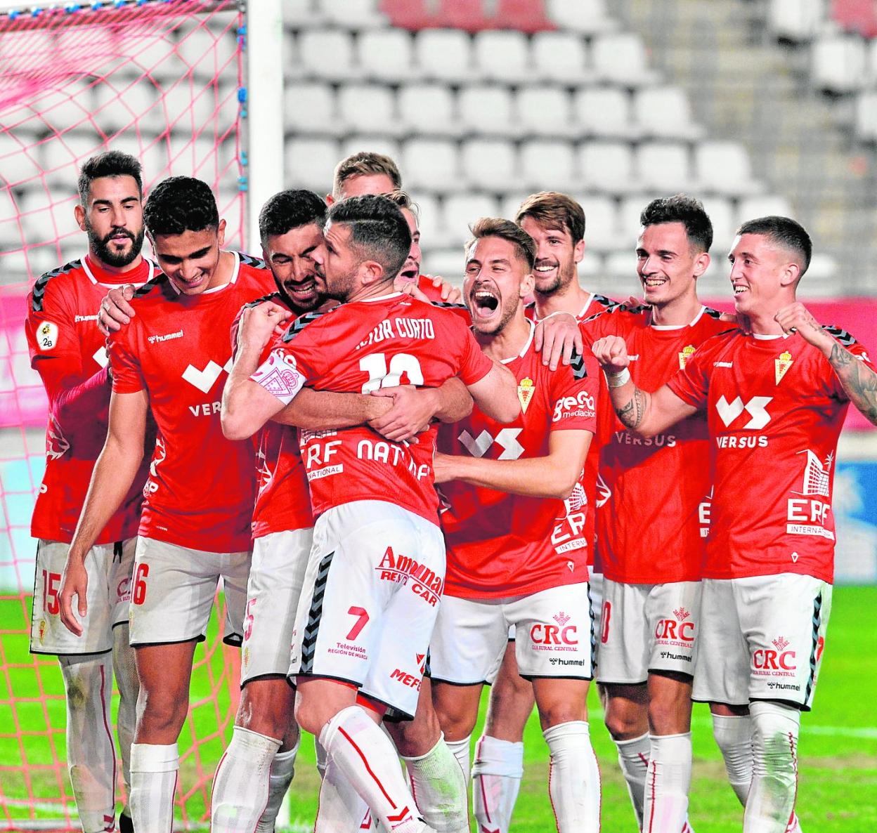 Curto, el pasado domingo, recibe el abrazo de Antonio López y la felicitación del resto de compañeros tras marcar el 2-1. 