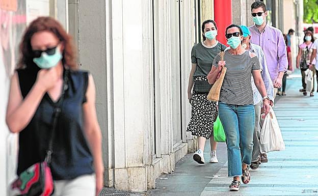 Viandantes con mascarilla, en una calle de Murcia. 