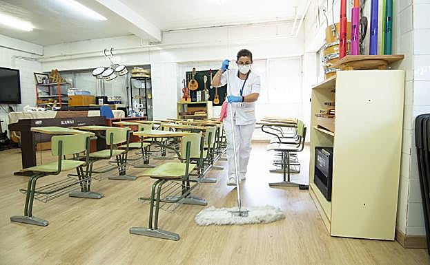 Una trabajadora limpia un aula del colegio público San Juan, en Murcia.
