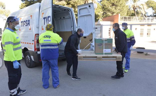 Dos trabajadores trasladan un cargamento de vacunas contra la Covid de la compañía Pfizer, este domingo, en una residencia de mayores de San Pedro del Pinatar.