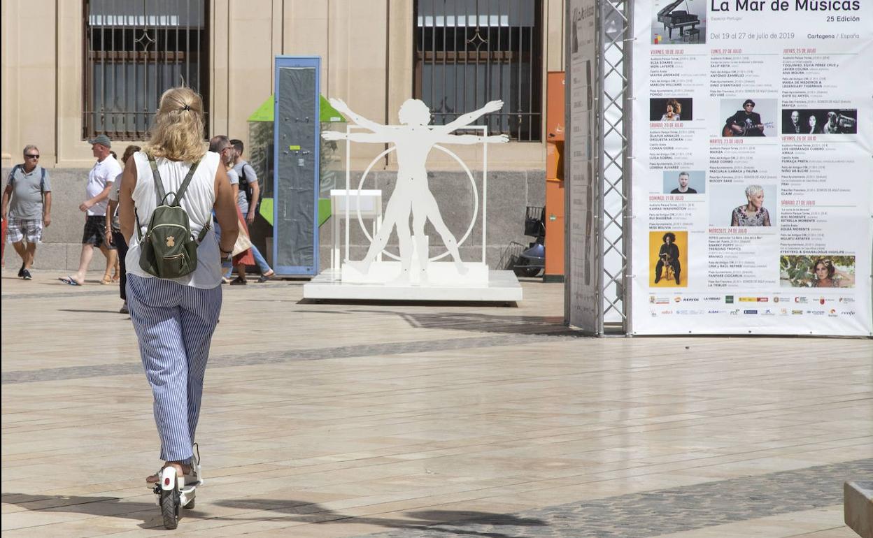 Una mujer circula por una zona peatonal en patinete. 