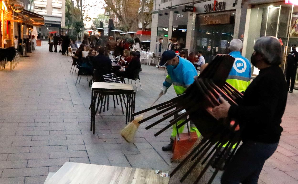 Un camarero recoge las sillas la pasada 'tardebuena' en Murcia.