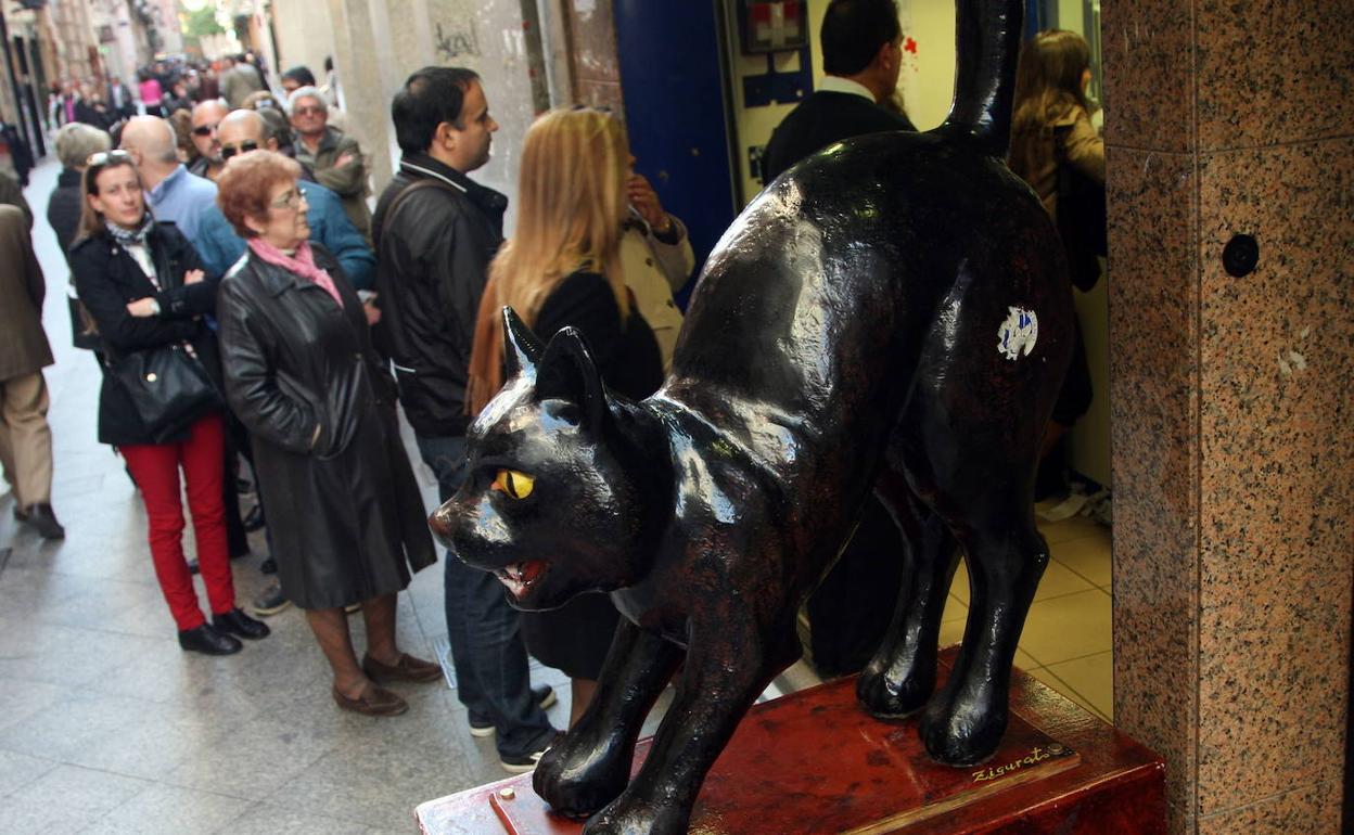 Clientes haciendo cola ante la administración de Loteriás de El Gato Negro durante el Sorteo del Niño del año anterior.