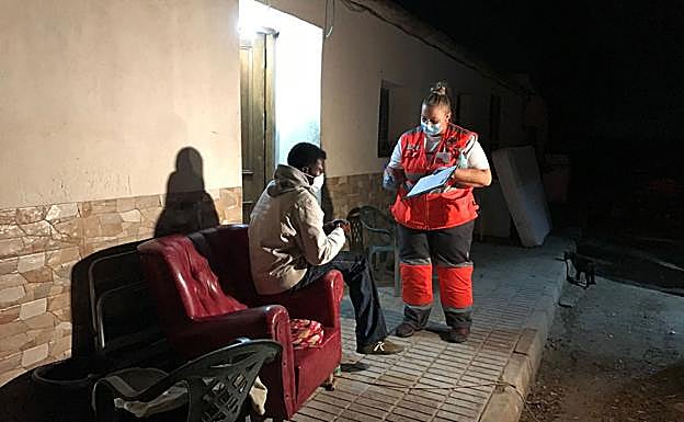 Una voluntaria de Cruz Roja atiende a una persona sin hogar en una calle de Cartagena. 