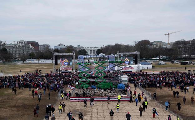 Algunas personas esperan en la Elipse de la Casa Blanca a que comience el acto de Trump.