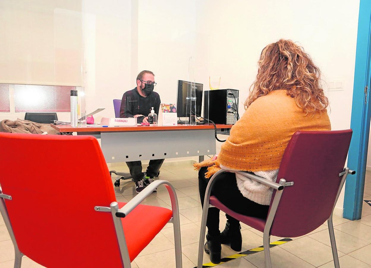 Un trabajador de Servicios Sociales atiende a una demandante de ayuda, ayer. 