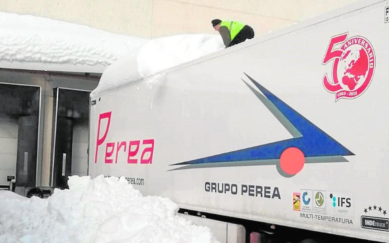 Un transportista retira la nieve acumulada en el techo de su camión, paralizado en Madrid estos días. 