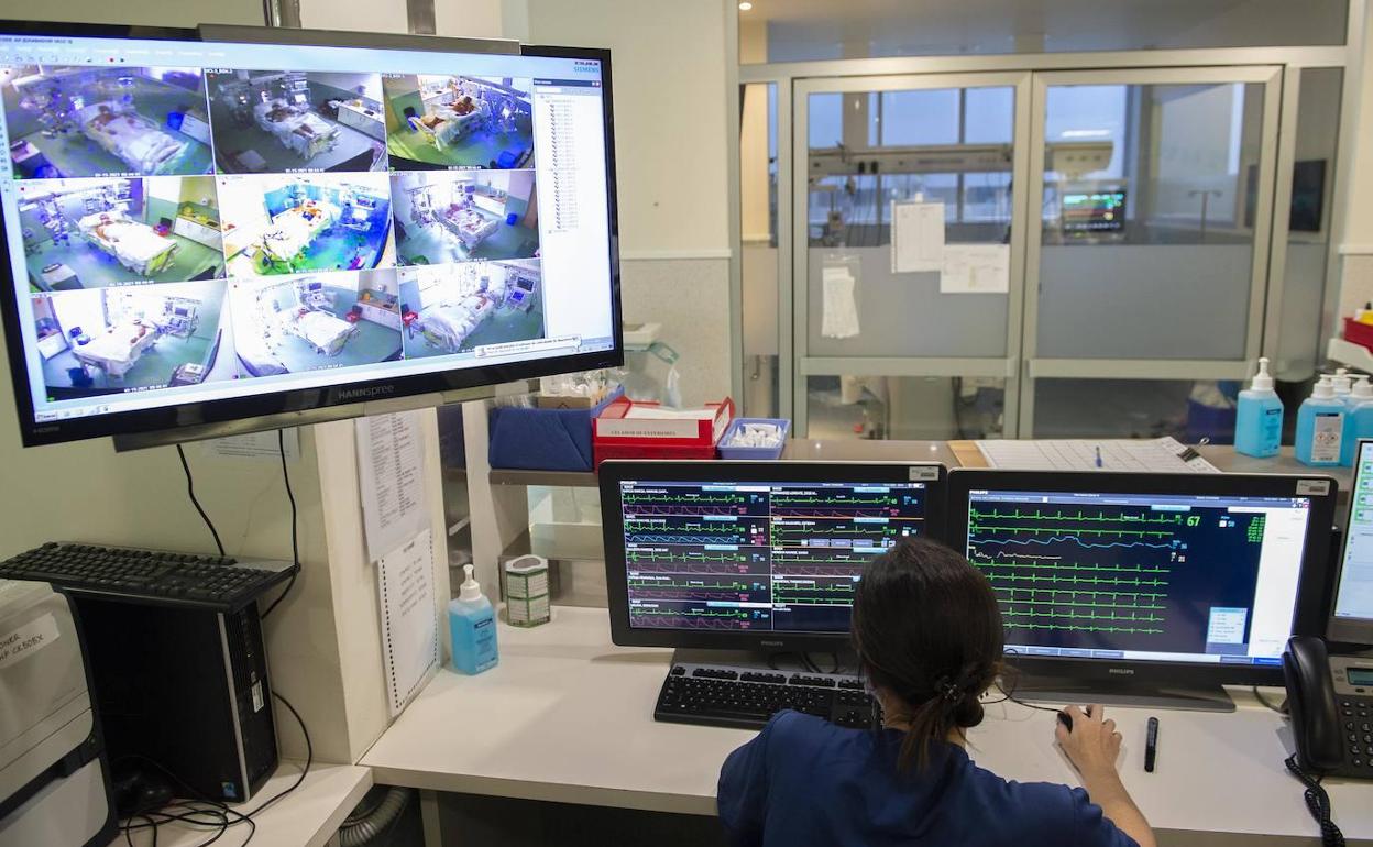 Una sanitaria monitorizando a enfermos en UCI en el hospital Santa Lucía de Cartagena.