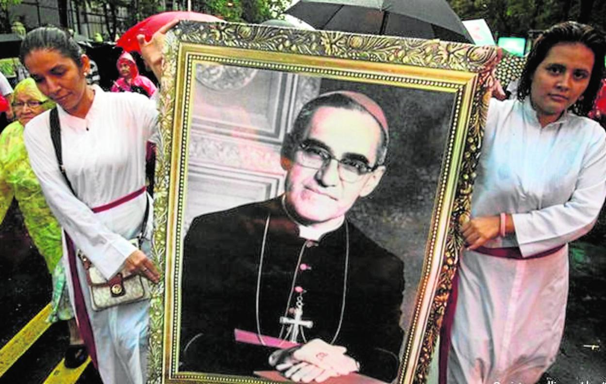 Dos jóvenes portan un retrato de monseñor Óscar Romero, asesinado el 24 de marzo de 1980.