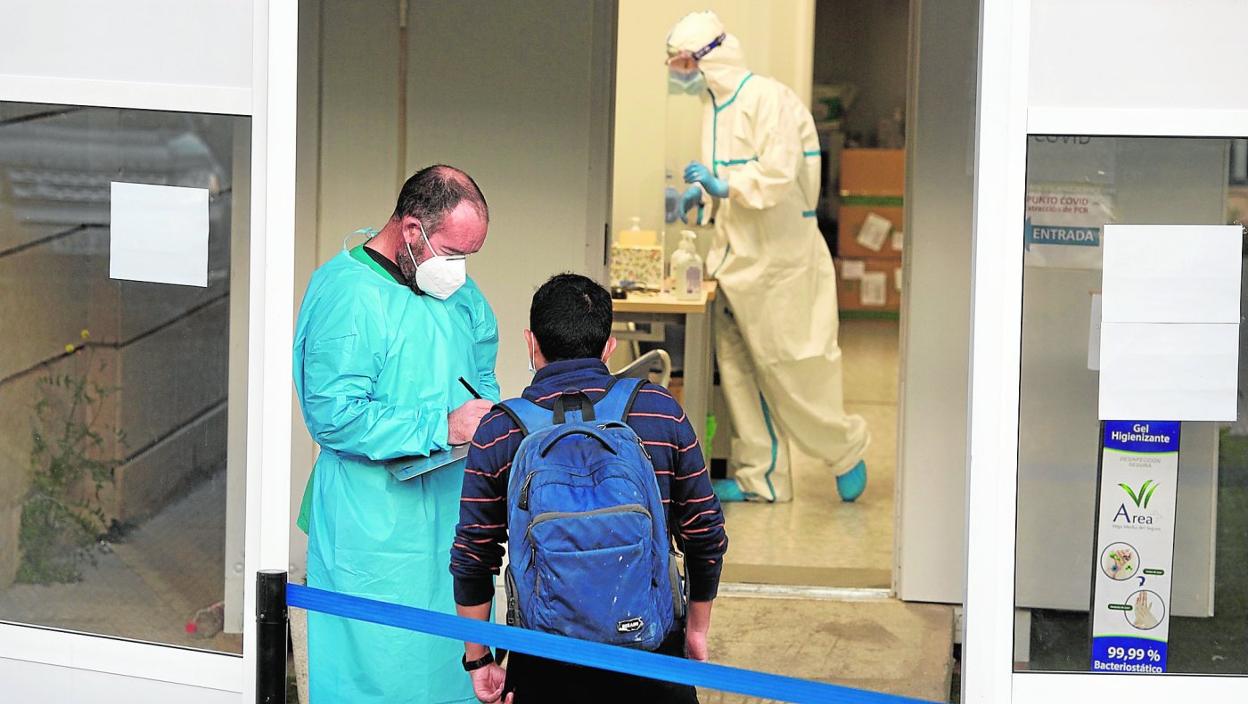 Un sanitario atiende a un paciente en la entrada al punto Covid situado en el Morales Meseguer, ayer. 