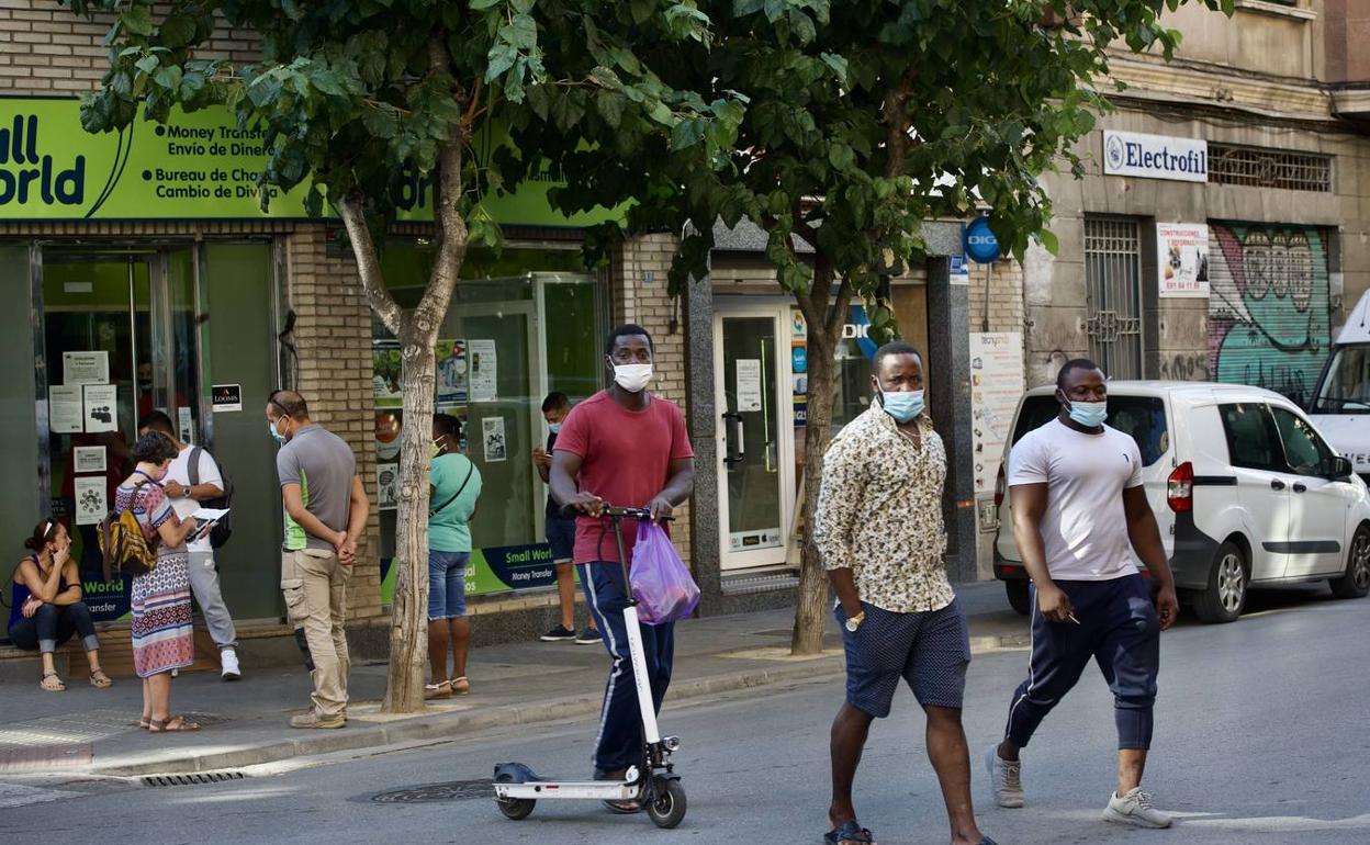 Varios inmigrantes caminan por una calle de Murcia en una imagen de archivo. 