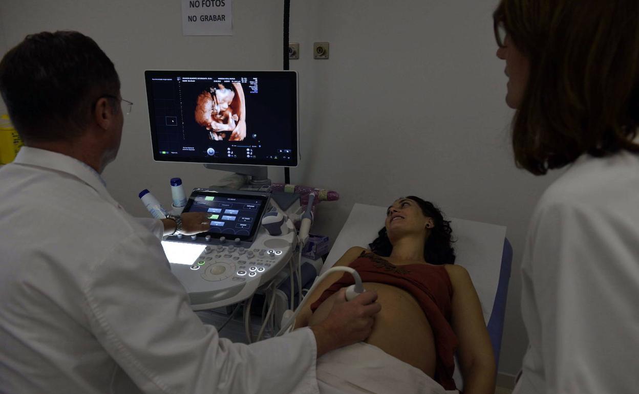 Un doctor realiza una ecografía a una embarazada.