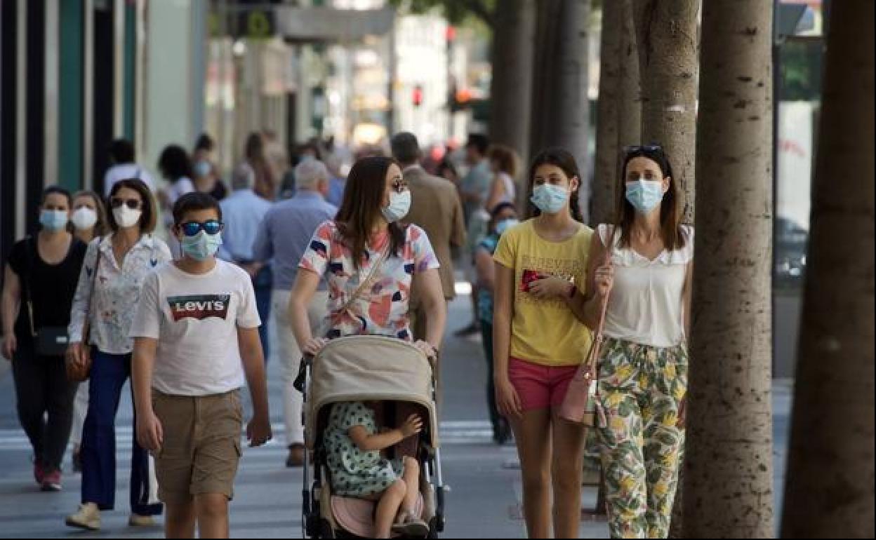 Personas con mascarillas en una foto de archivo.