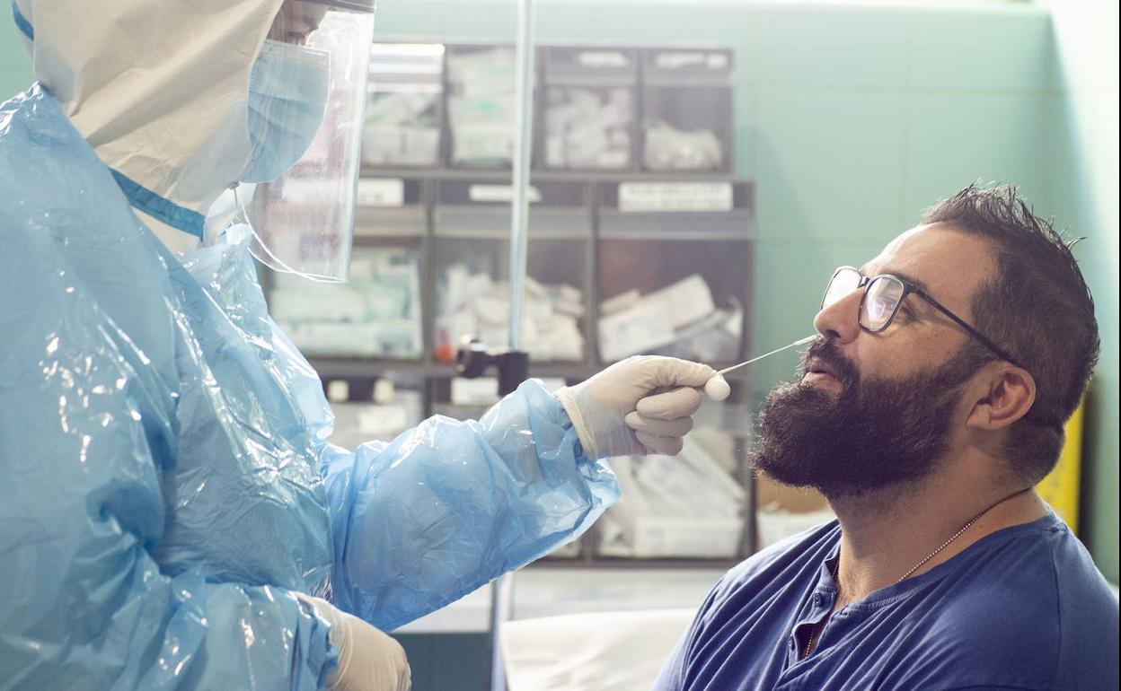 Un sanitario realiza una prueba PCR a un varón, en el hospital Reina Sofía.