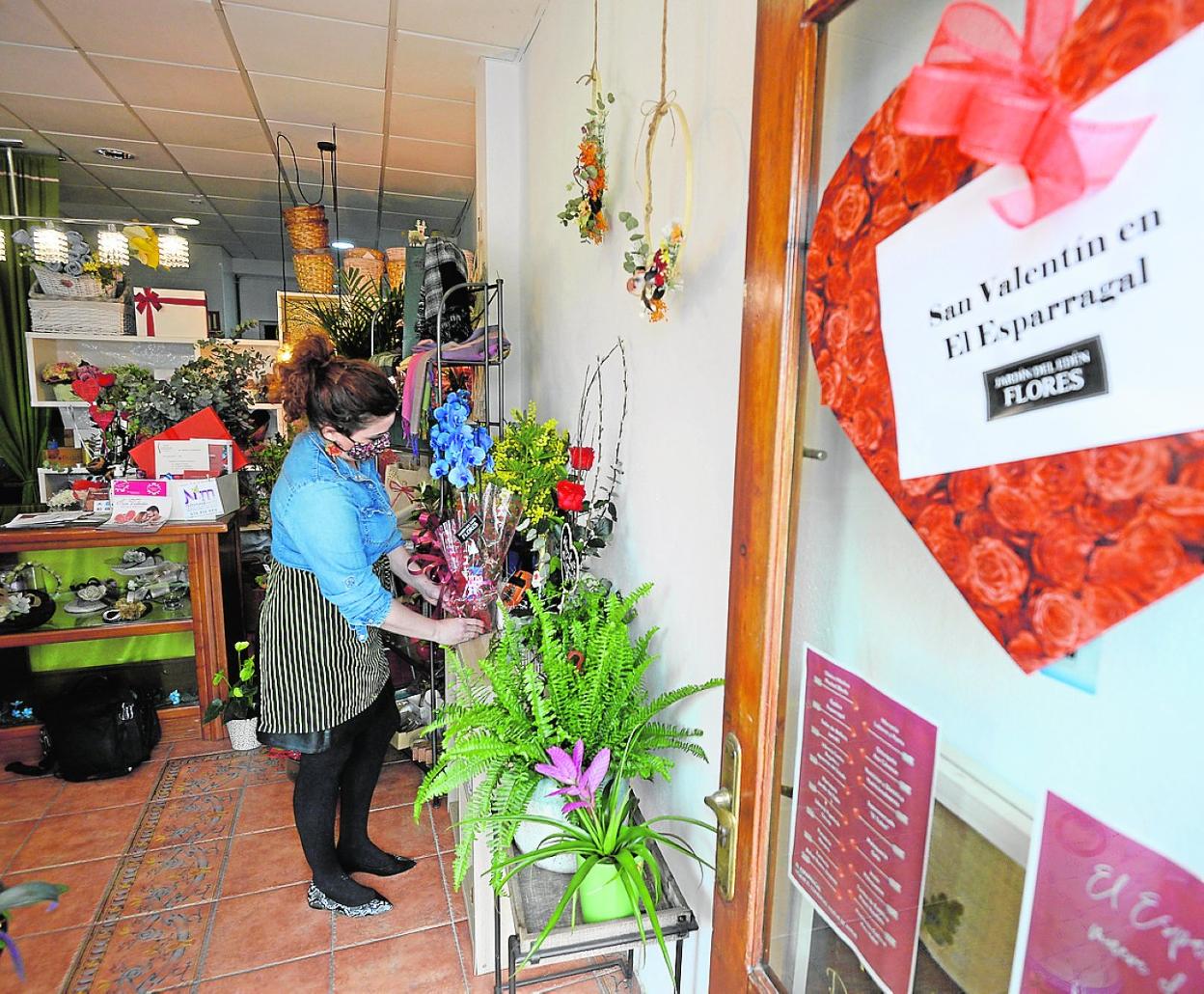 Cristina, de la Floristería Jardín del Edén, arregla un ramo; al fondo la 'caja del amor'. 