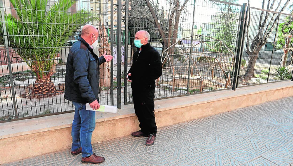 Sosa (i) y el coordinador local de IU, junto a la valla del centro. 