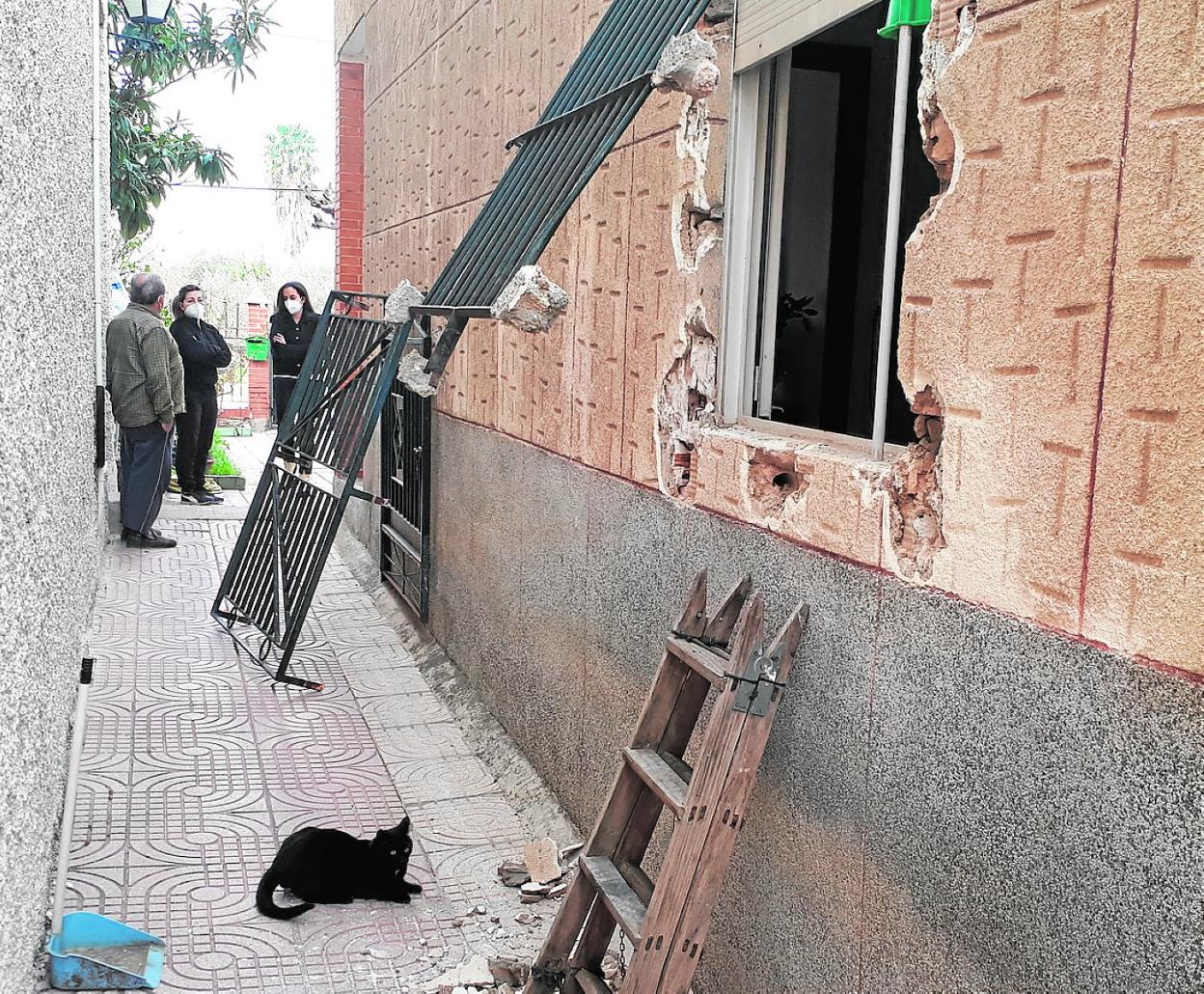 Fulgen Bermejo (c) y Carmen Robles observan dos rejas reventadas por los ladrones, hace unos días. 