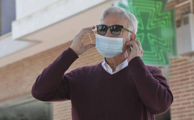 Un vecino de Murcia se coloca una mascarilla recogida en una farmacia. 