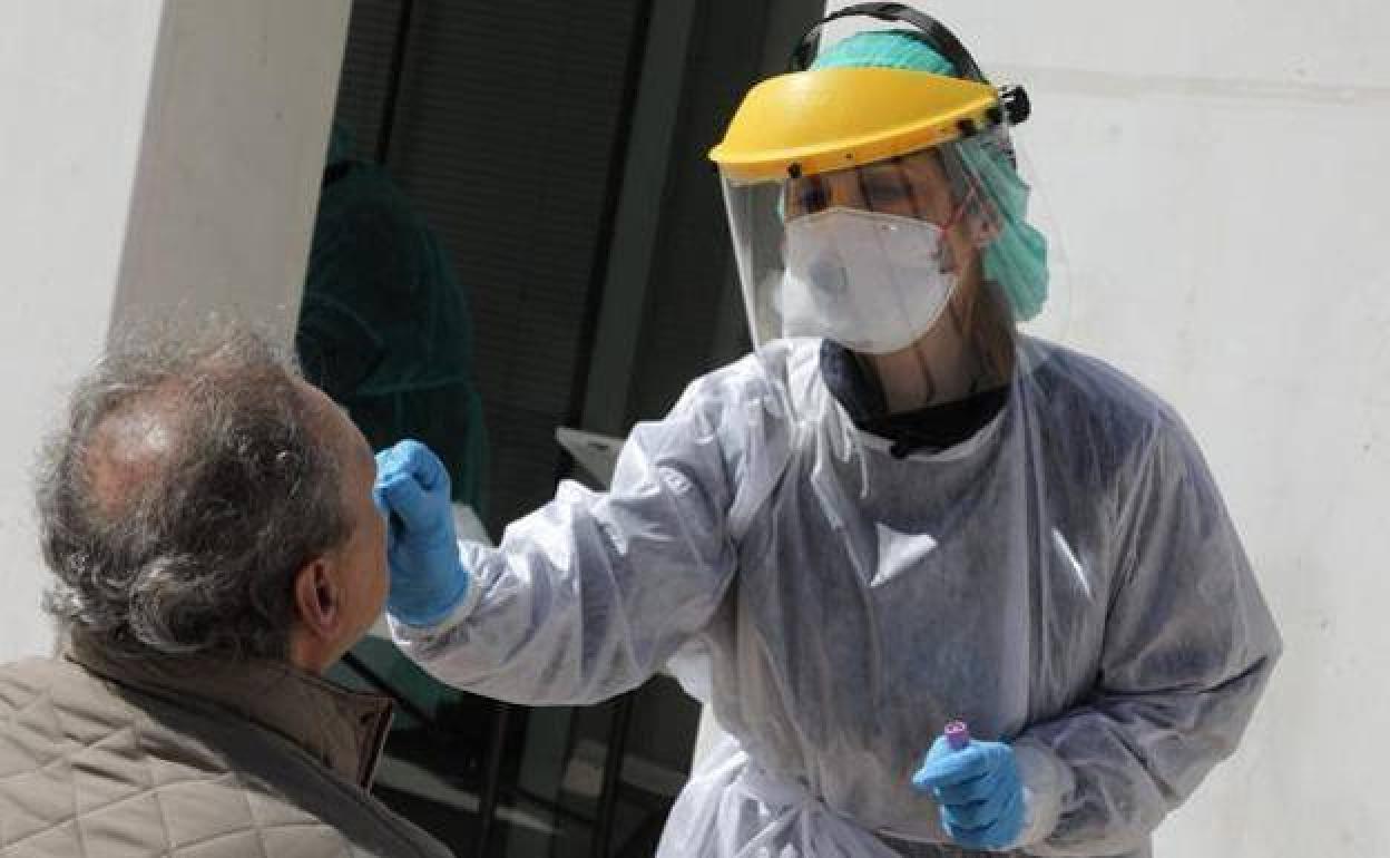 Un sanitario realiza una prueba PCR a un paciente, en una fotografía de archivo.