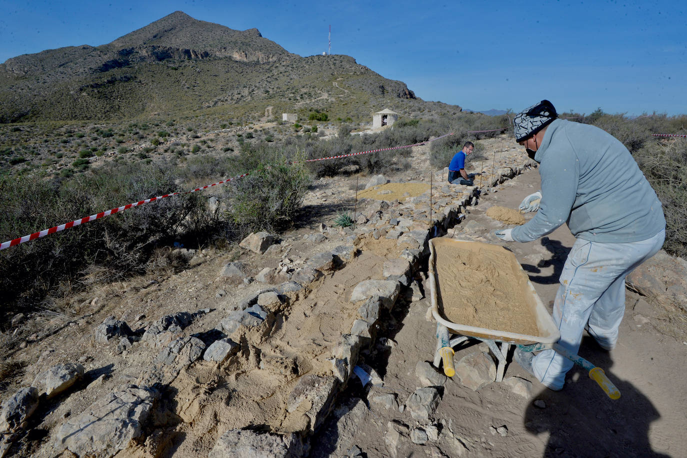 Dos operarios trabajan en la recuperación del tramo oeste de la muralla.