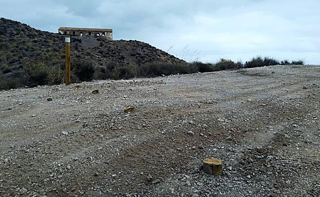 Bolardos serrados en la entrada a la cala del Cuartel. Al fondo, cuartel de la Guardia Civil abandonado del Ciscar (o Siscal, en Lorca).