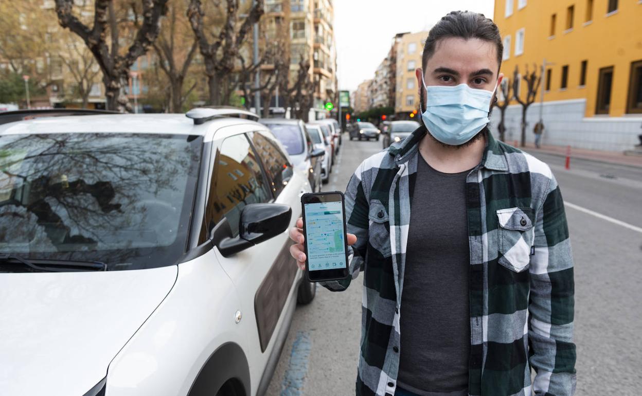 El joven alcantarillero David García muestra la 'app' 'Apárcame', en la avenida Rector José Lostau de Murcia.