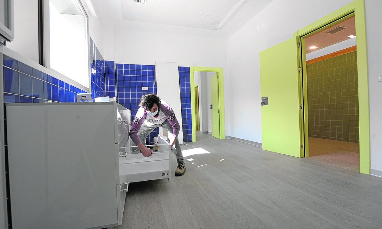 Un carpintero da los últimos retoques a un mueble de la nueva zona del consultorio. 