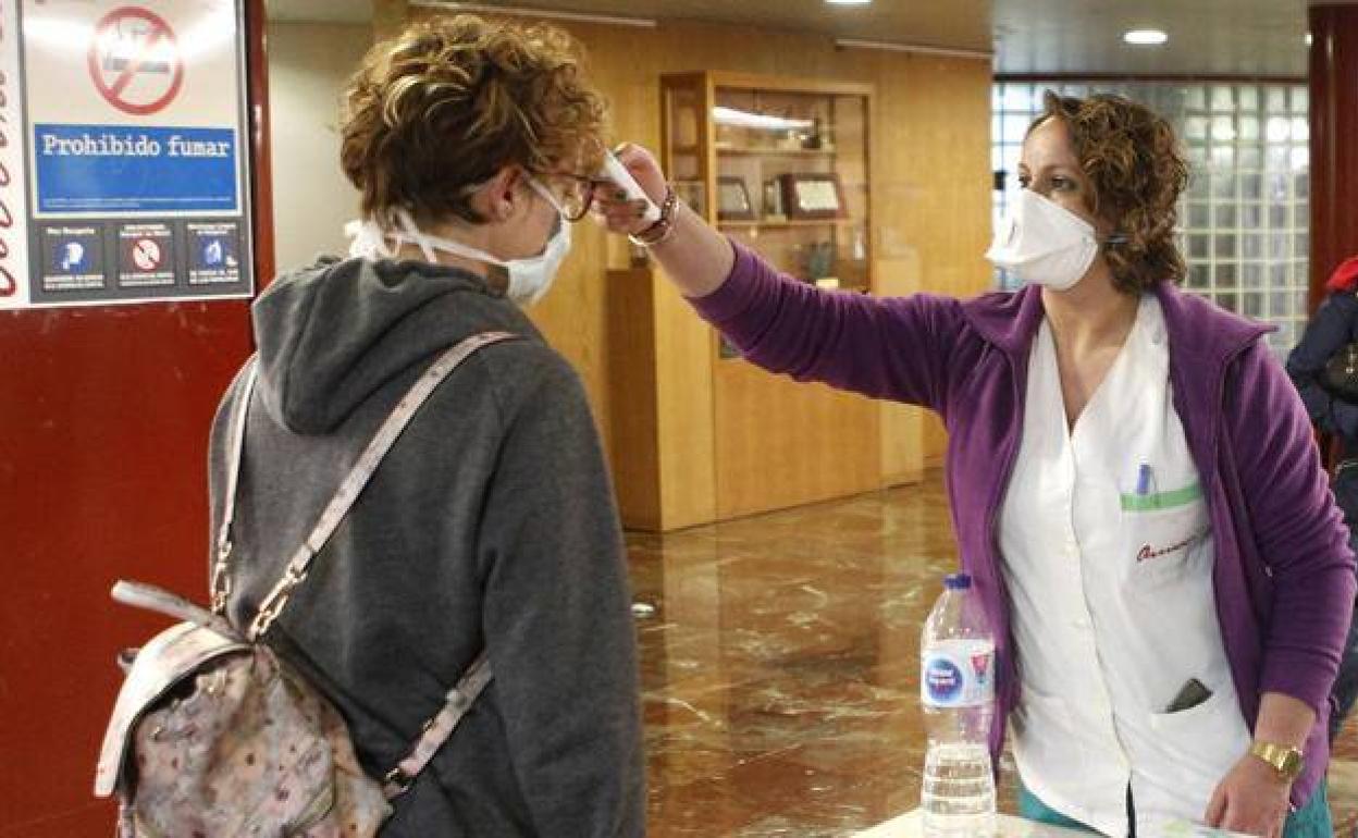 Una sanitaria toma la temperatura a una mujer en La Arrixaca, en una imagen de archivo. 