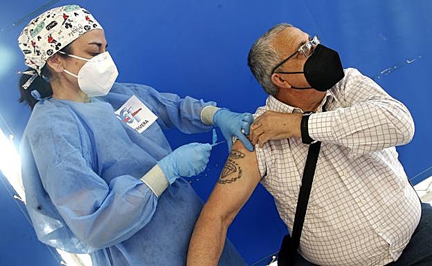 Una enfermera administra una vacuna. 