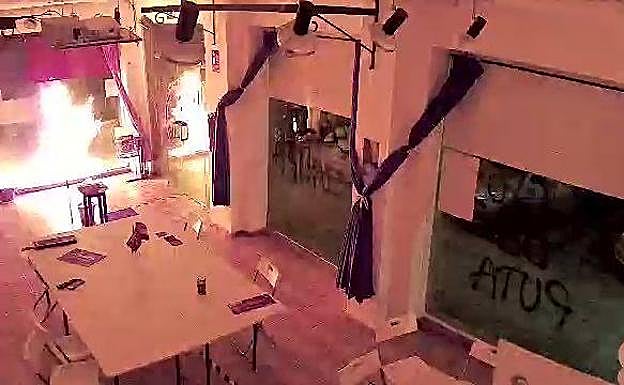 Imagen de la cámara de seguridad del interior de la sede de Podemos en Cartagena tras impactar material explosivo en el cristal del establecimiento.