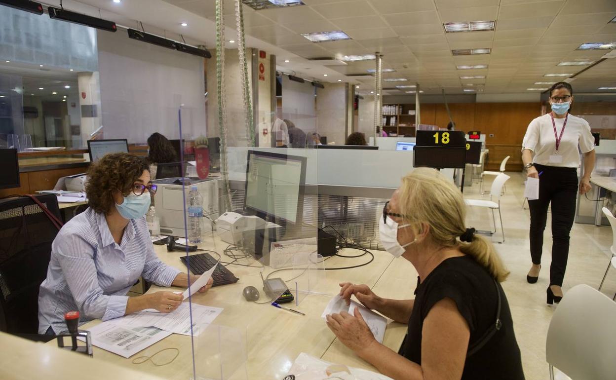 Una funcionaria atiende a una contribuyente en la Consejería de Hacienda, en una foto de archivo