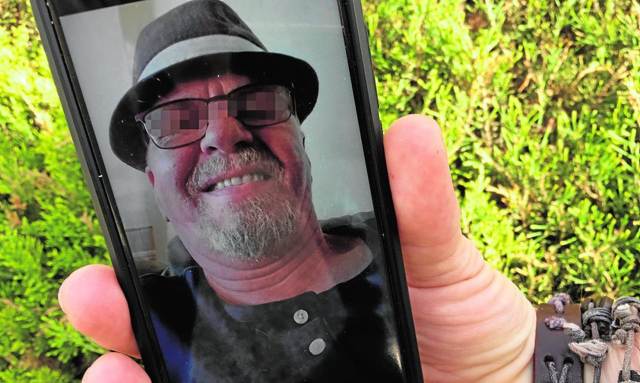 Un vecino muestra en su teléfono móvil una fotografía del sospechoso, al que en la localidad conocían como 'El inglés'. 