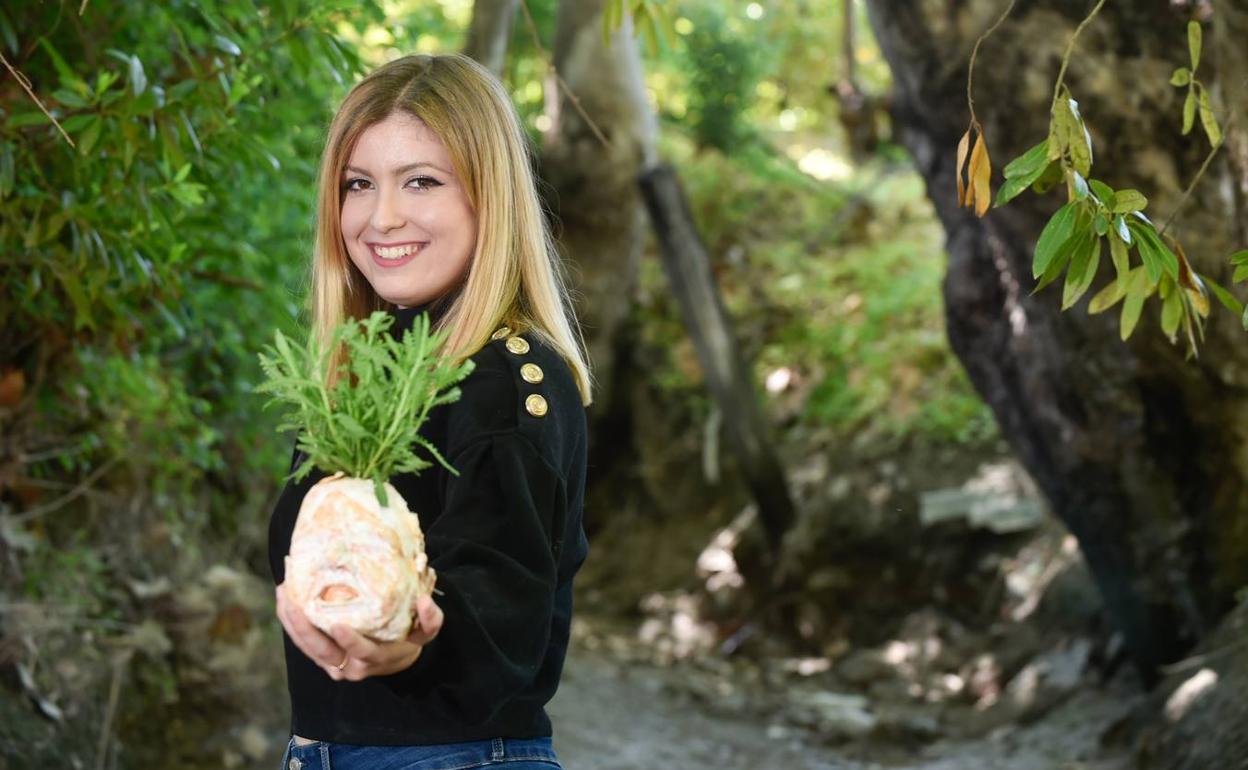 Marisol Gorem, con una de sus obras, unas plantas en tiestos con forma de cabeza de bebé. 